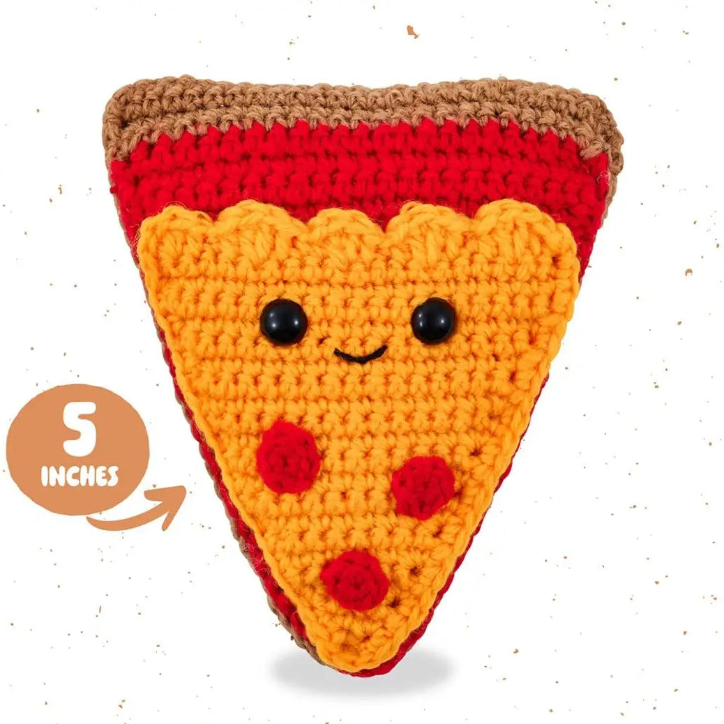 Crocheted pizza slice toy with a smiley face on a white background