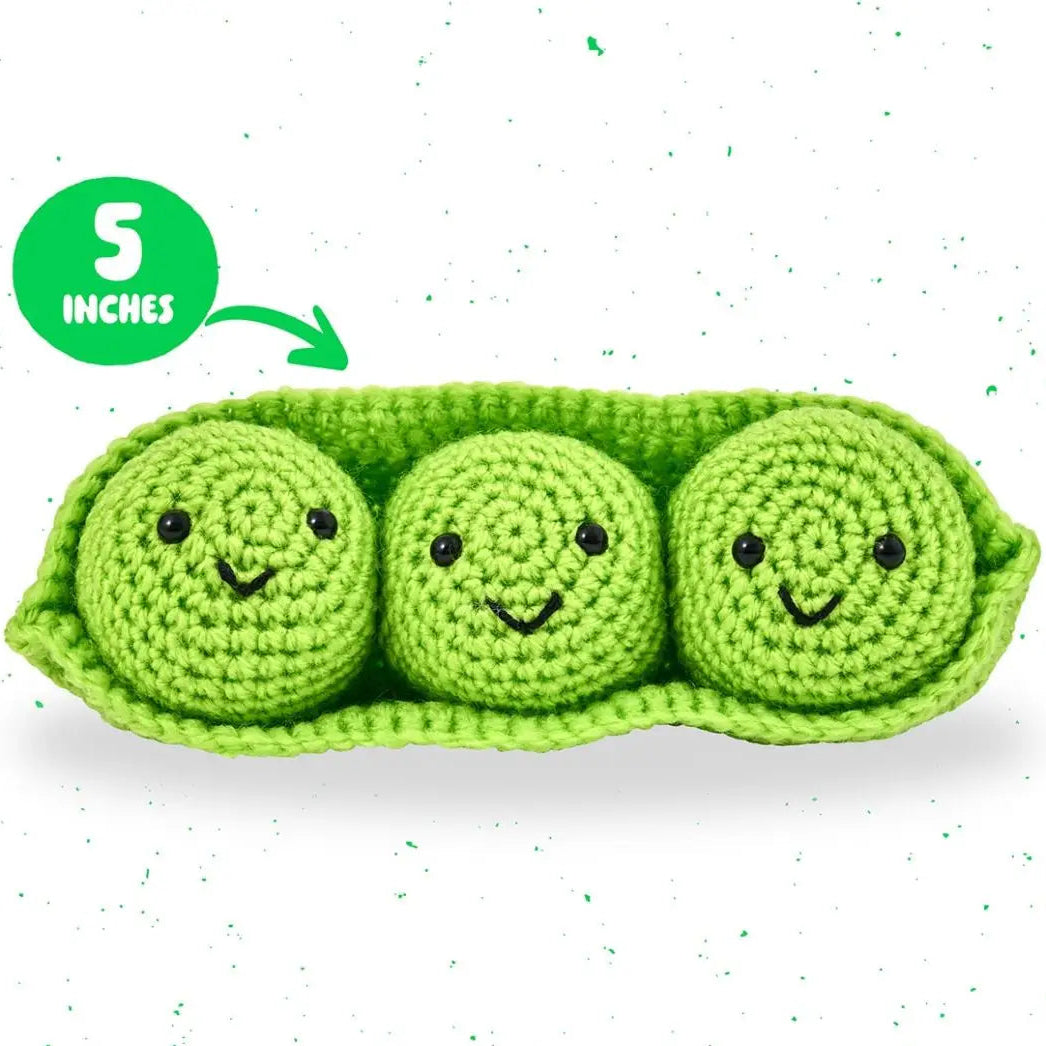 Crocheted toy with three green peas in a pod on a white background