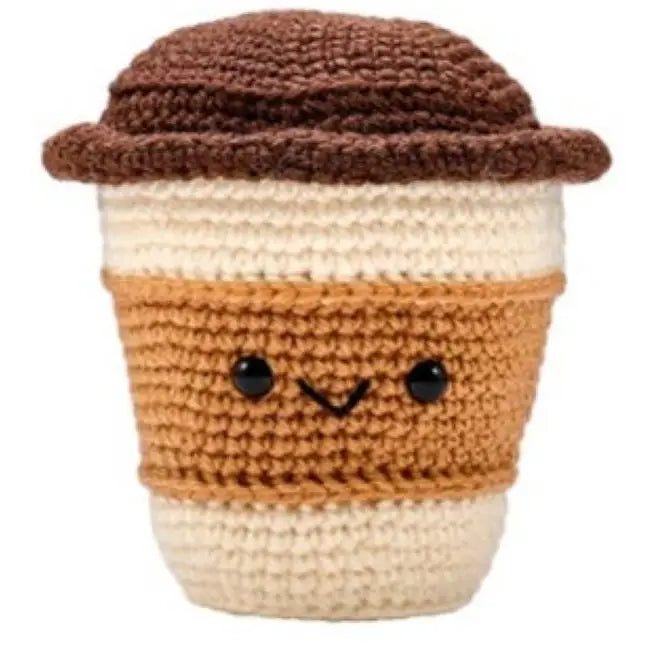 Crocheted coffee cup with a smiling face on a white background